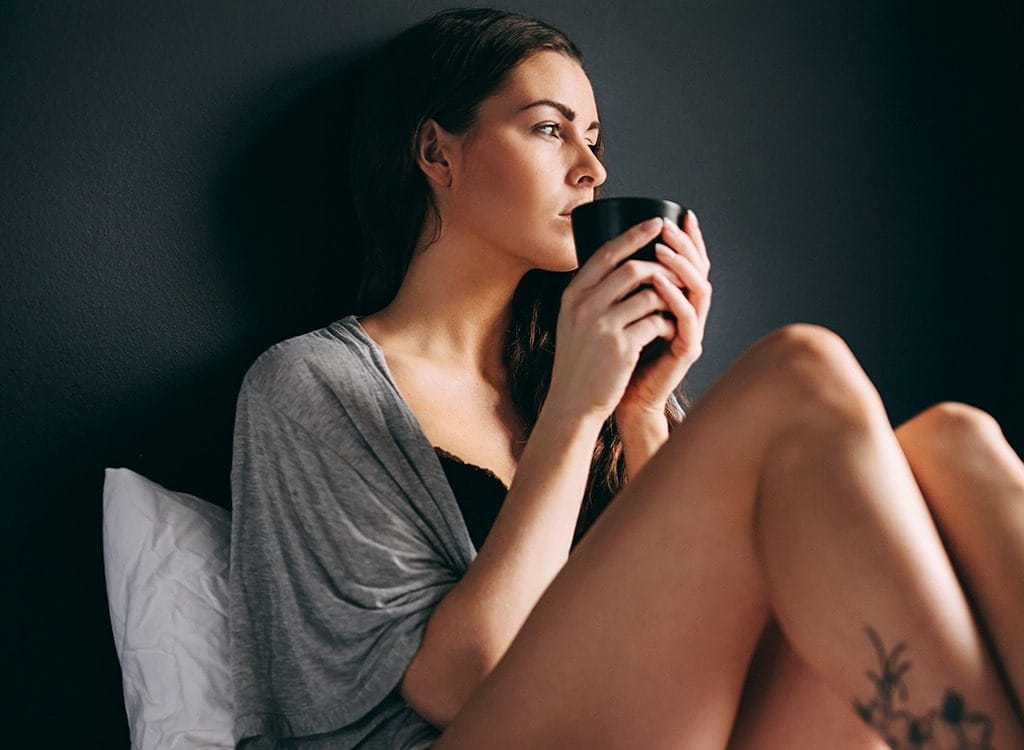 Femeie singura care bea cafeaua in pat